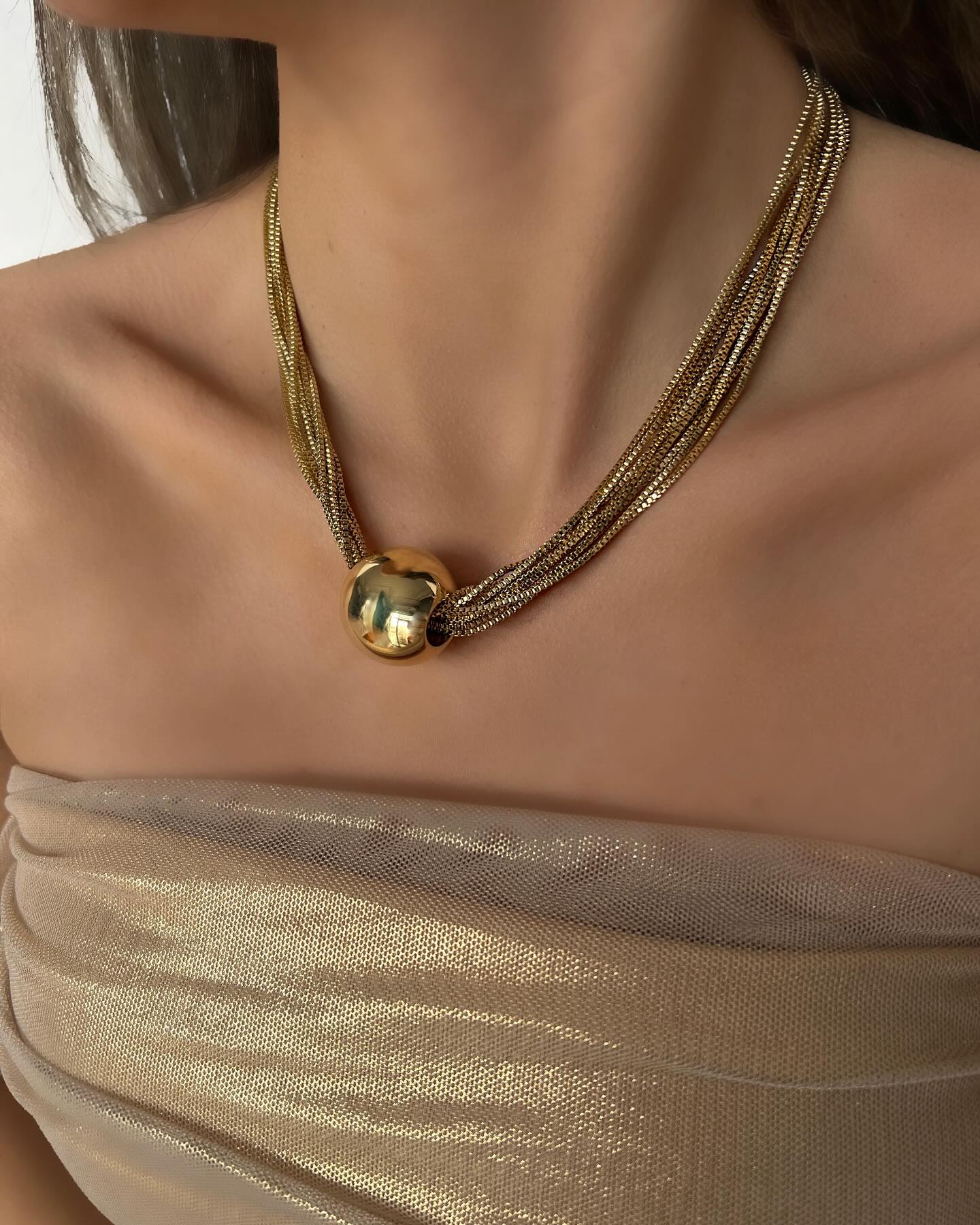 Large single gold bead on a delicate chain, a minimalist necklace that adds effortless elegance.