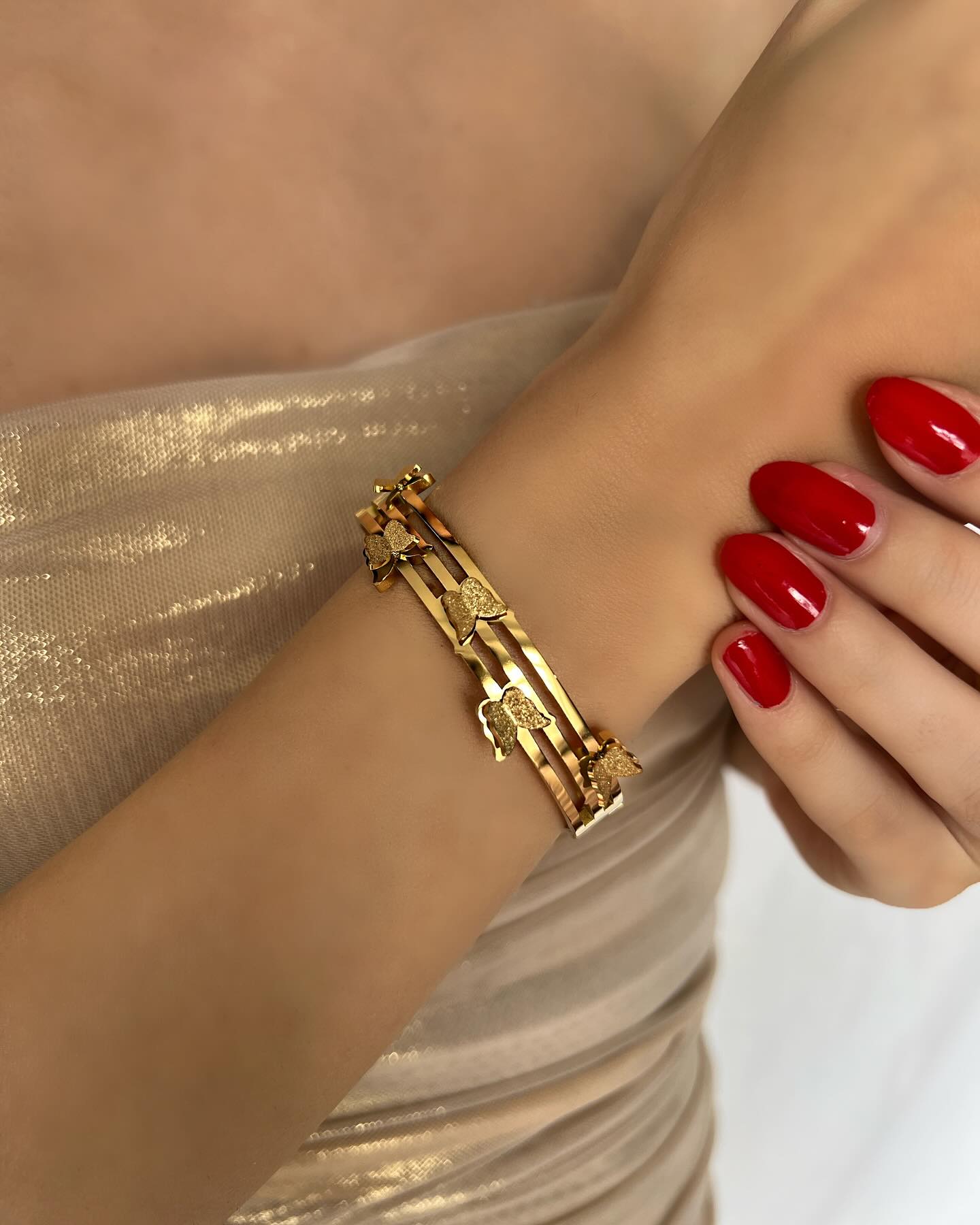 Butterfly-detailed cuff bracelet, a graceful design that combines elegance with feminine charm.
