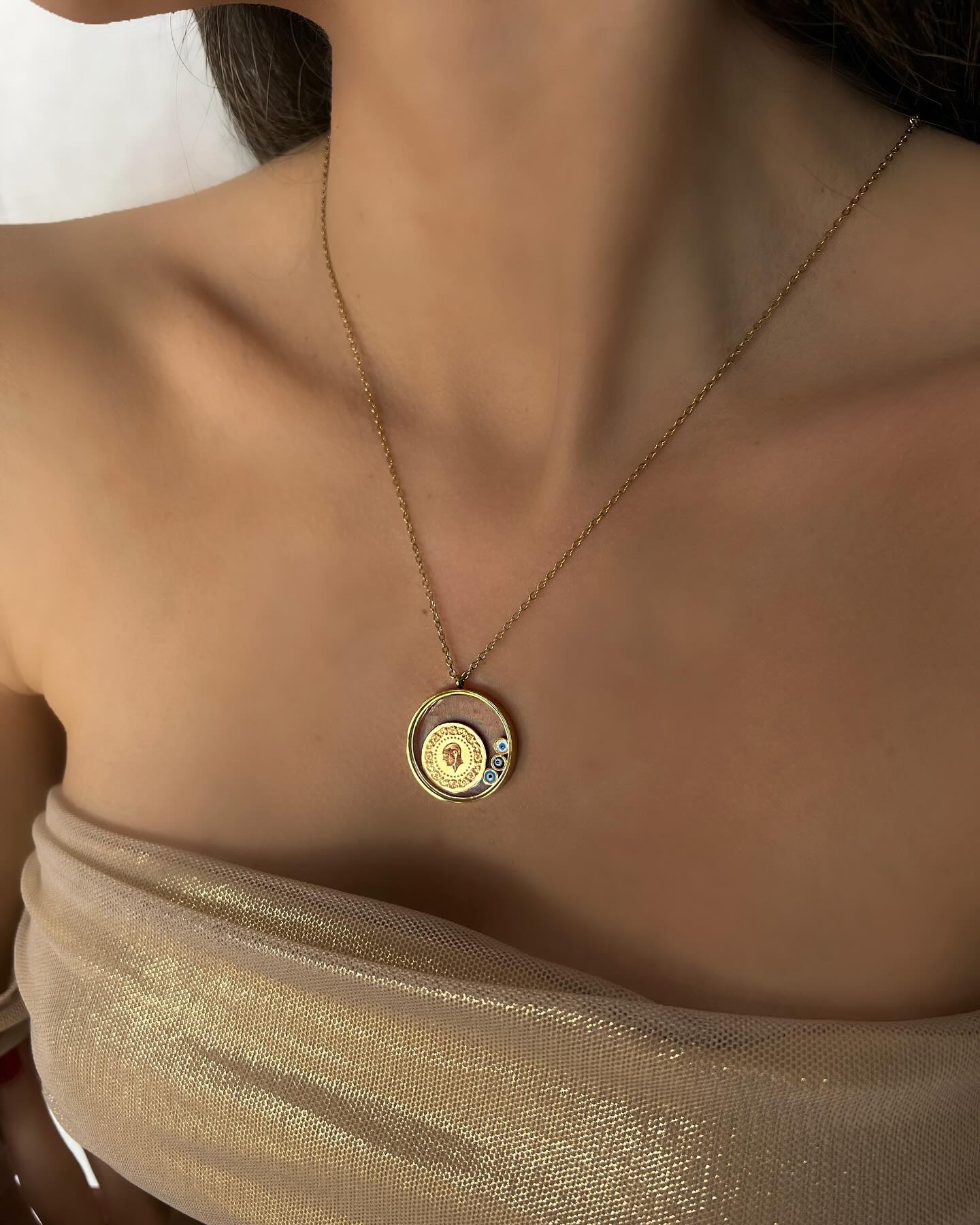 Evil eye charm on a gold circle design, a protective necklace that blends style and meaning.