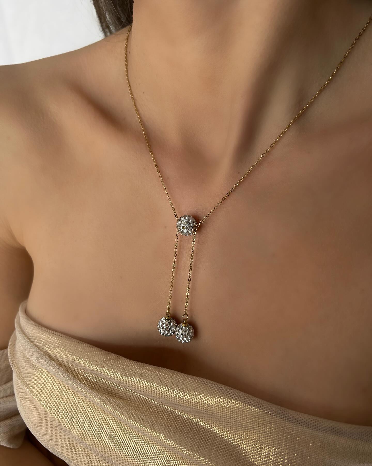 Three small diamond-accented beads, a delicate necklace that adds a subtle touch of sparkle.
